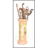 An early 20th Century stoneware stick stand together with a collection of four stick stands and
