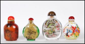 A group of four 20th Century Chinese snuff bottles to include three reverse painted bottles in the