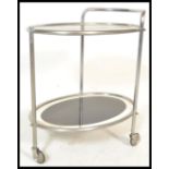 An early 20th Century Art Deco chrome and glass two tier drinks trolley. Each panel of oval form