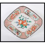 A 19th century Chinese Wucai dish of lozenge form being handpainted with fruit tree cartouche