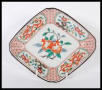 A 19th century Chinese Wucai dish of lozenge form being handpainted with fruit tree cartouche