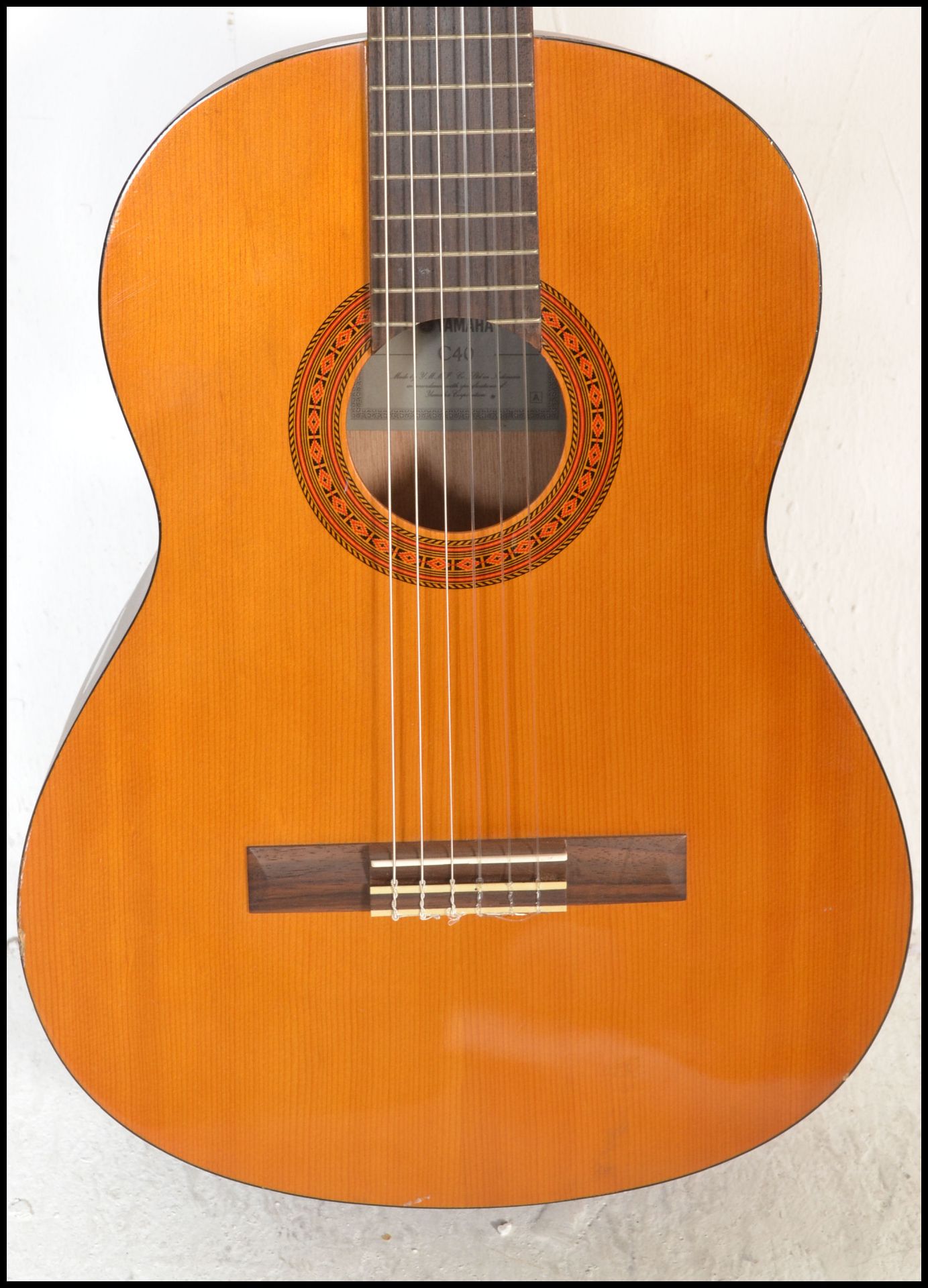 A Yamaha C40 six string acoustic guitar having a shaped hollow body with white tuning pegs and paper - Bild 2 aus 4