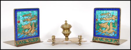 A pair of 20th Century Chinese brass bookends having enamelled panels with raised Chinese dragons