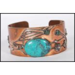 An early 20th Century Arts and Crafts bangle bracelet having a copper body with applied silver