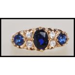 A hallmarked 9ct gold ladies ring set with three blue stones to the head with white accent stones.