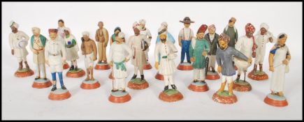 A collection of 21 Indian terracotta and wire figurines being raised on round bases having hand