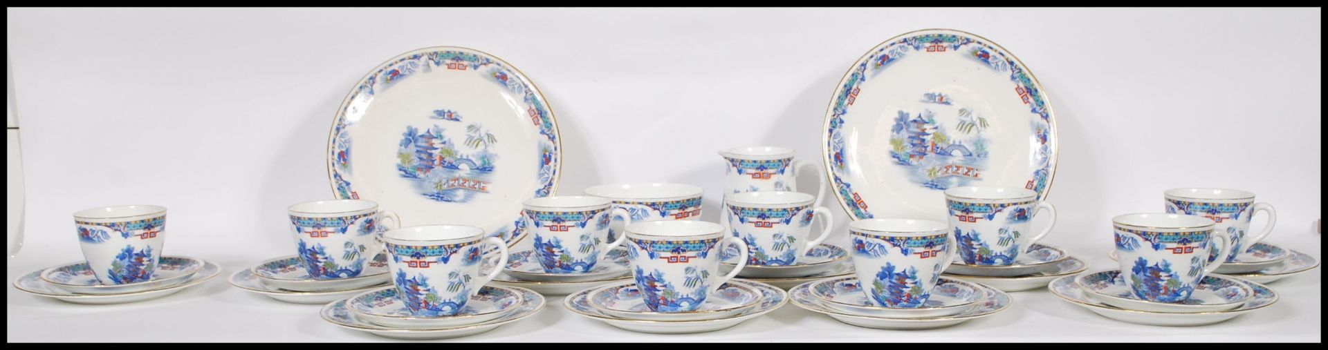 A 20th Century Staffordshire blue and white tea service in the Willow pattern, having red and