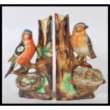 A pair of early 20th Century novelty ceramic book ends modelled as nesting birds in trees, one
