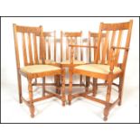 A set of five early 20th Century Art Deco oak dining chairs, slated back with carved back rail, drop