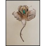 A stamped 900 Colombian silver brooch in the form of an orchid flower being set with a raw