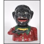 A vintage 20th Century cast iron money bank, being cold painted in black and red with a mechanical