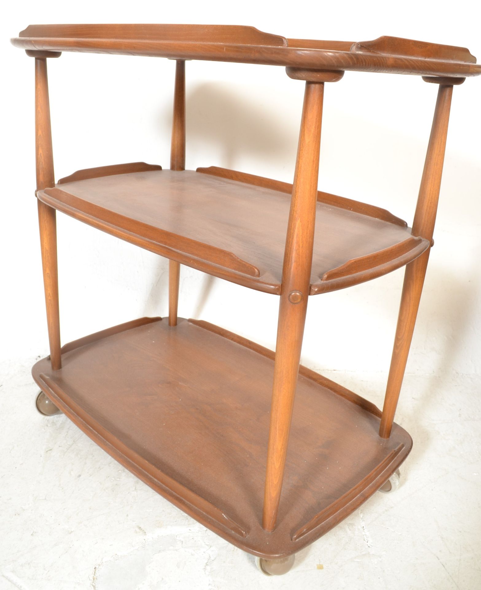 A vintage 20th century Ercol Golden Dawn 3 tier butlers serving buffet trolley. The elm tiers raised