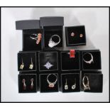 A collection of eleven cased silver ( stamped 925 ) dress rings and earrings, set with coloured