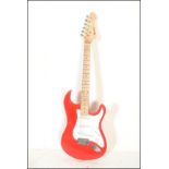 A vintage Rockburn electric six string guitar. The red body having white scratch guard with chrome