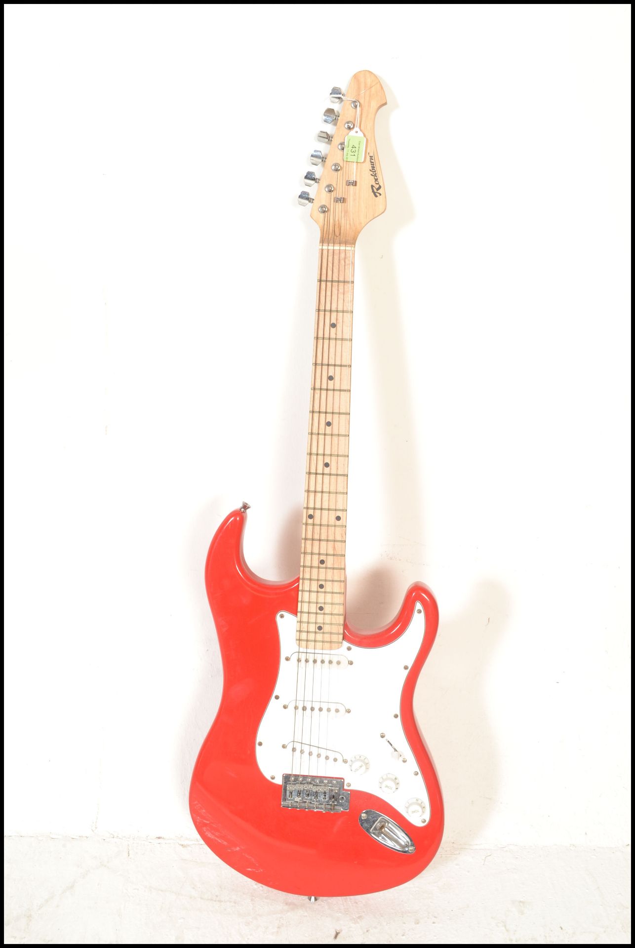 A vintage Rockburn electric six string guitar. The red body having white scratch guard with chrome