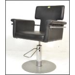 A pair of 20th Century barber chairs, the adjustable seats and backrests upholstered in faux black