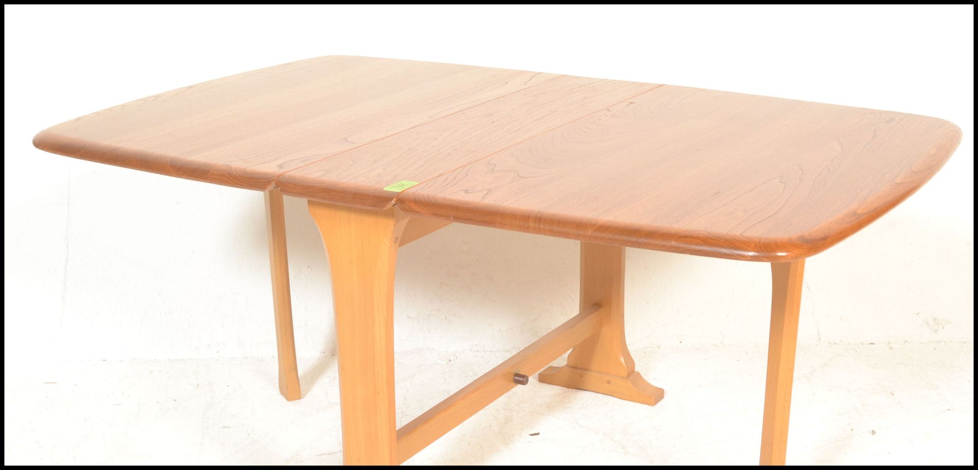 An Ercol beech and elm wood light drop leaf sutherland occasional - coffee table being raised on - Bild 3 aus 5