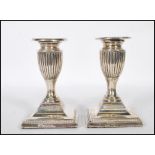A pair of late Victorian silver London hallmarked candlesticks of stub form having single sconces,