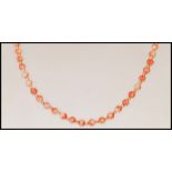 A vintage coral beaded necklace having a 9ct gold spring ring clasp with gold tone spacer beads.
