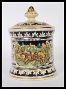 A vintage 20th century German stoneware tobacco jar humidor pot having relief scenes of lions and