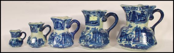 A set of five graduating 20th Century flow blue hydro water jugs in the manner of Mason's. The