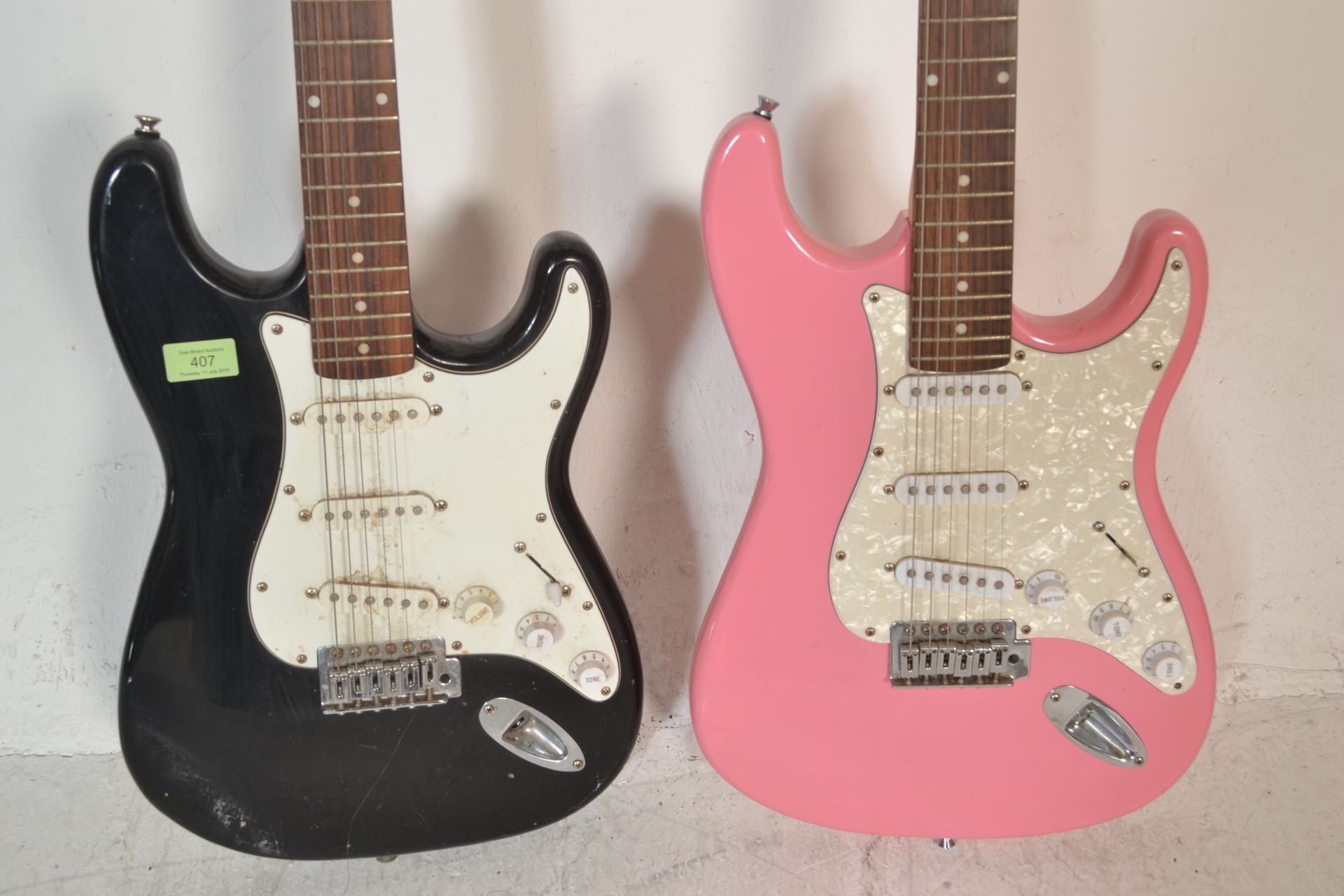 Two 20th Century Stratocaster style six string guitars by Encore, one having a pink body and the - Bild 3 aus 4