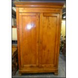 A 19th century French fruitwood  armoire wardrobe being raised on bracket feet with twin doors