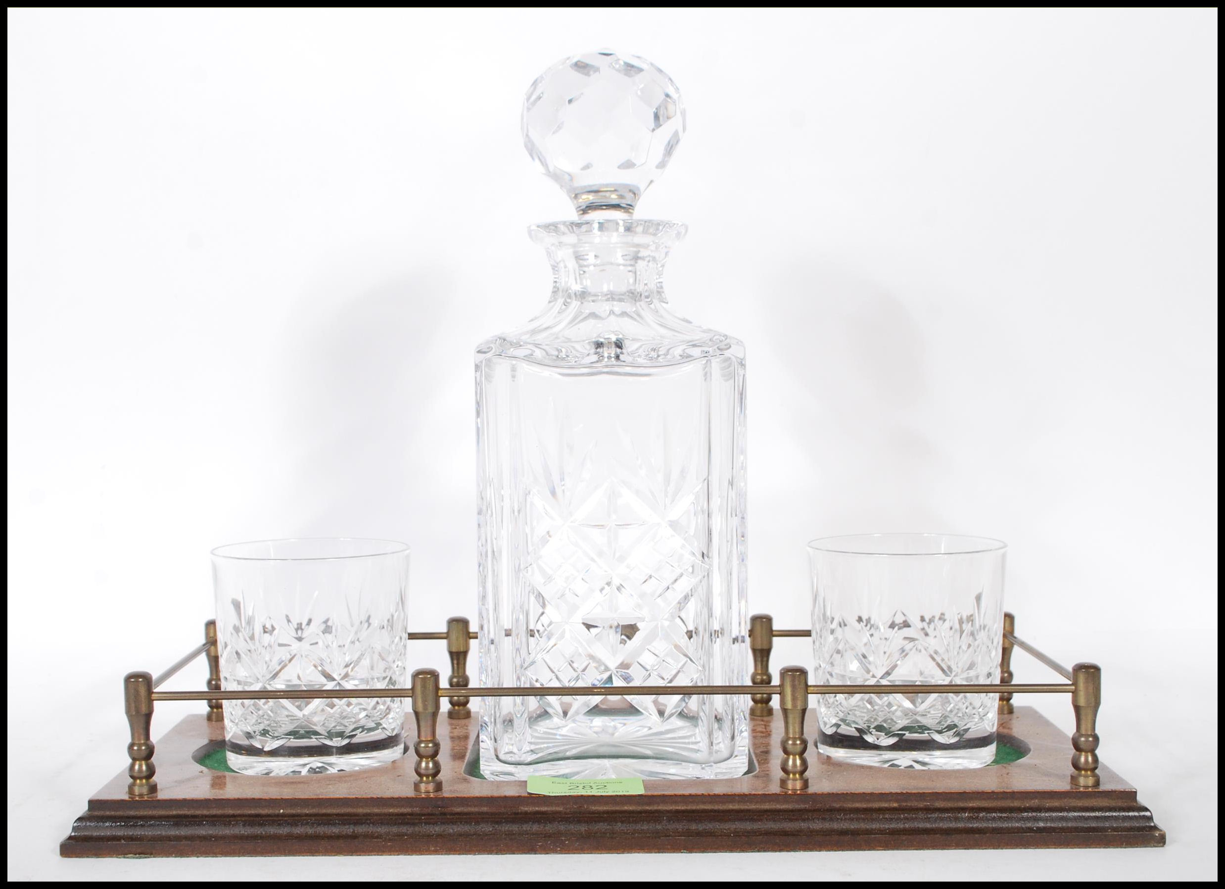 A vintage 20th Century cut glass decanter set having a stepped wooden base with a cut glass decanter