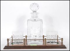 A vintage 20th Century cut glass decanter set having a stepped wooden base with a cut glass decanter