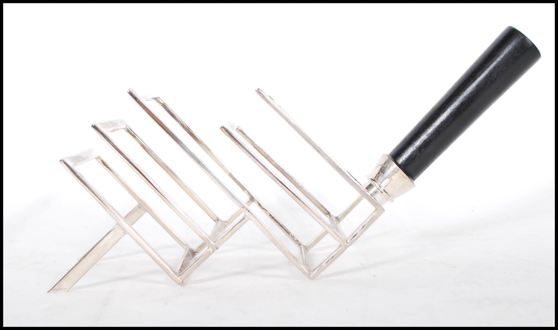 A Christopher Dresser manner toast rack being of silver plated construction with ebonised turned