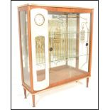 A vintage retro glass fronted mirror back cocktail display cabinet with painted glass detailing, the