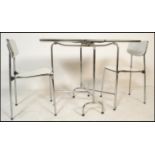 A vintage mid 20th Century drop leaf kitchen dining table raised on a chrome frame together with a