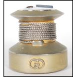 A vintage 20th Century Gucci table lighter of round form having a silvered logo to the front, and