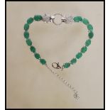 A silver and emerald line / tennis  bracelet with panther style designer clasp surrounding halo to