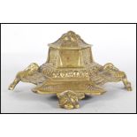 An early 20th Century cast brass inkwell of stepped hexagonal form decorated with birds and floral