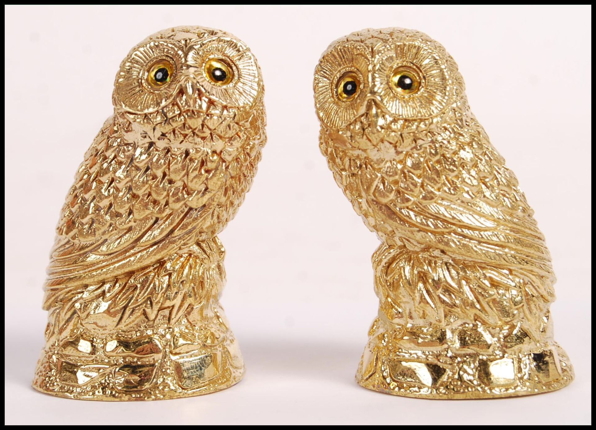 A pair of 18ct gold plated condiments in the form of owls having yellow and black glass eyes.
