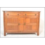 An early 20th Century oak sideboard buffet with quarter panel twin cupboard doors having two drawers