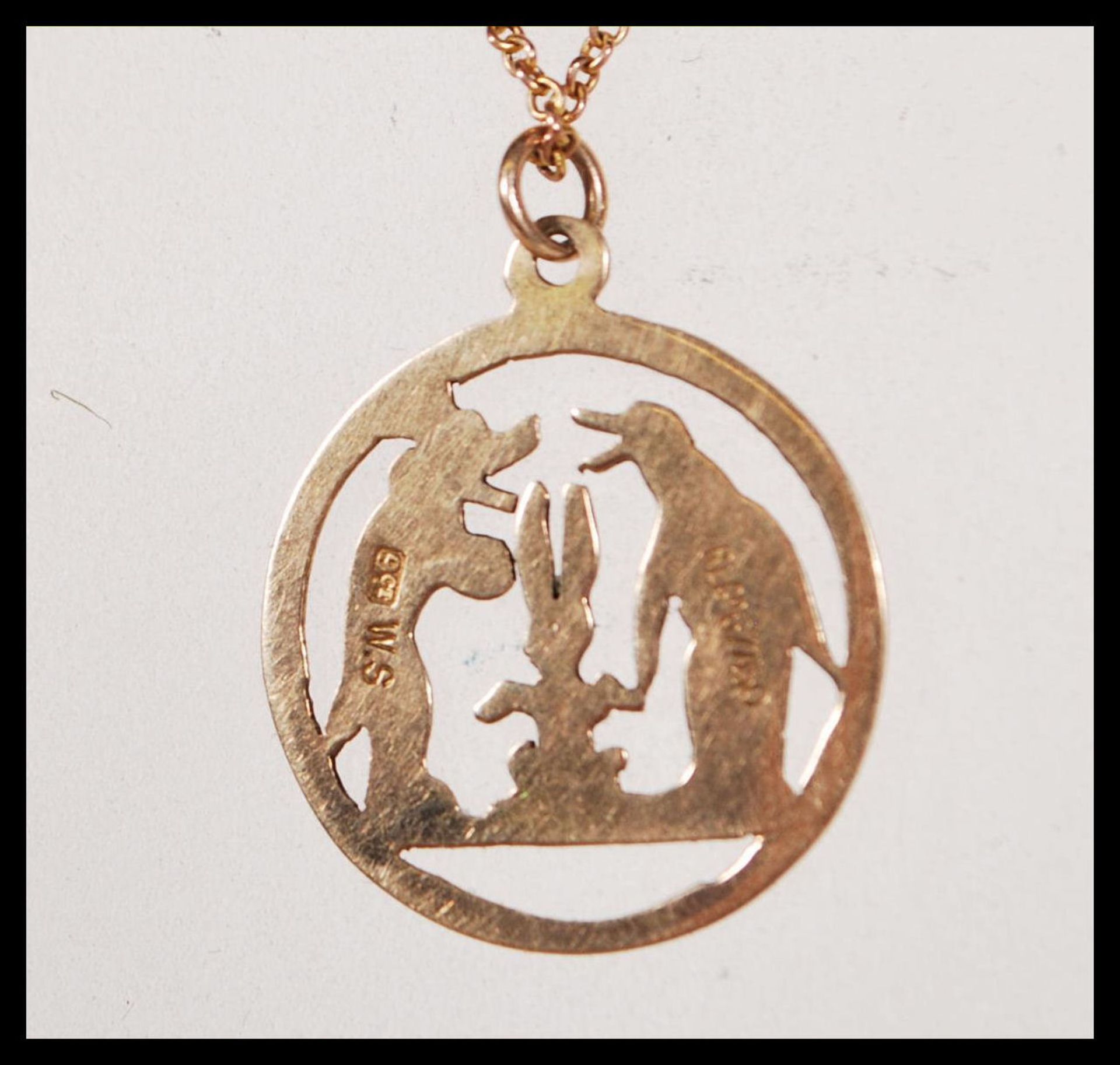 A stamped 9ct gold necklace having a round pendant having pierced decoration in the form of a dog, - Bild 5 aus 6