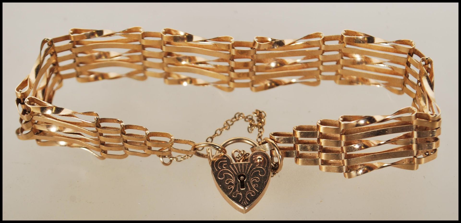 A hallmarked 9ct gold gate bracelet with tapered ends and attached heart-shaped padlock. - Bild 2 aus 5