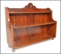 A Victorian walnut waterfall bookcase. The shaped wide body with graduating shelves and gallery