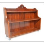 A Victorian walnut waterfall bookcase. The shaped wide body with graduating shelves and gallery