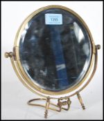 A 20th Century brass bevelled edge swing mirror of circular form raised on adjustable easel stand.