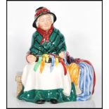 A Royal Doulton porcelain figure 'Silks and Ribbons ' no HN2017 depicting an old lady sat on a bench