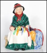 A Royal Doulton porcelain figure 'Silks and Ribbons ' no HN2017 depicting an old lady sat on a bench