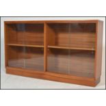 A mid century / circa 1960's teak wood and glass library bookcase cabinet. Of low form being solid