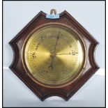 A 20th Century wall barometer of hexagonal form having around brass dial within a mahogany case.