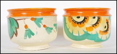 A pair of 1930's Art Deco planters / vases decorated in the style of Clarice Cliff with bright vivid