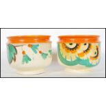 A pair of 1930's Art Deco planters / vases decorated in the style of Clarice Cliff with bright vivid