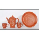 A 20th Century Chinese red clay Yixing tea for two service consisting of square teapot and two
