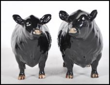 Two 20th Century Beswick ceramic figures modelled as an Aberdeen Angus Bull 1562 and Cow 1563.